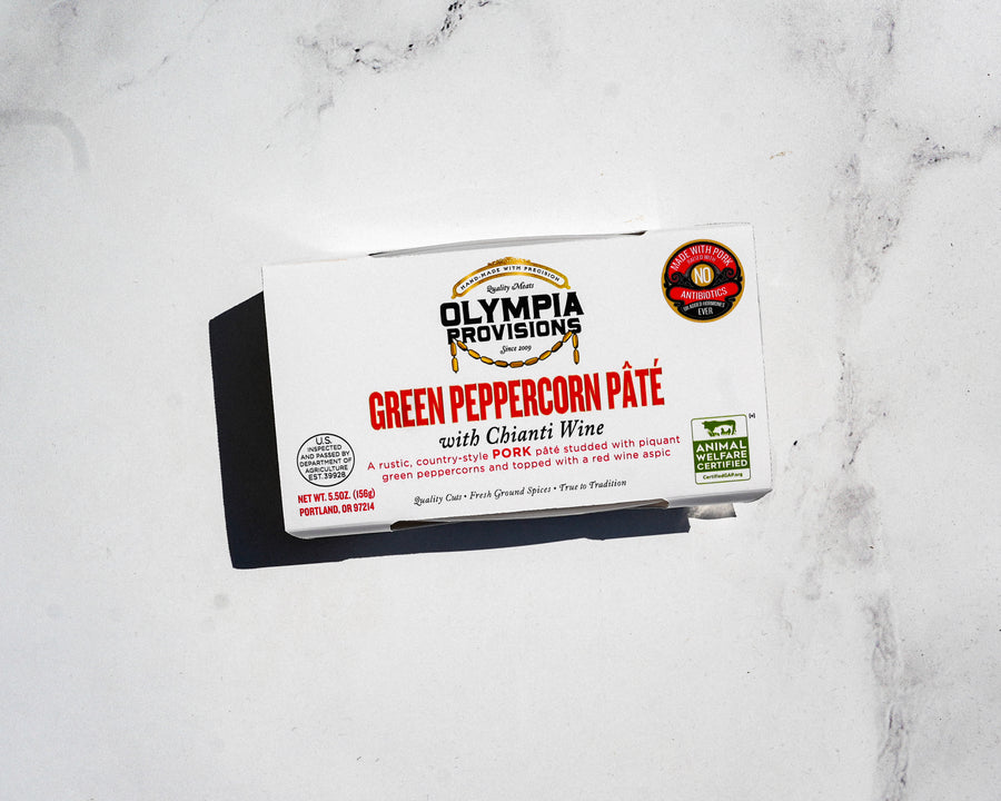 Box of Olympia Provisions Green Peppercorn Páté with Chianti Wine on a marble surface