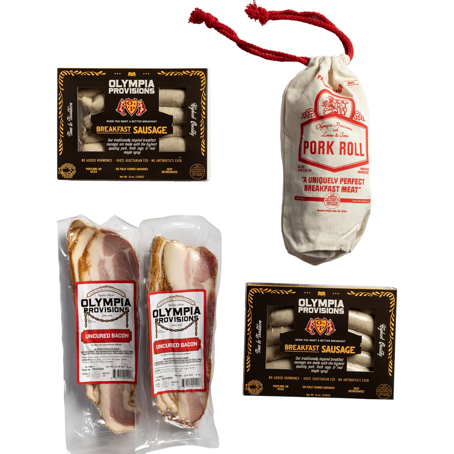 Two Olympia Provisions sausages in black packaging, two packages of sliced uncured bacon, and one pork roll in a canvas bag.