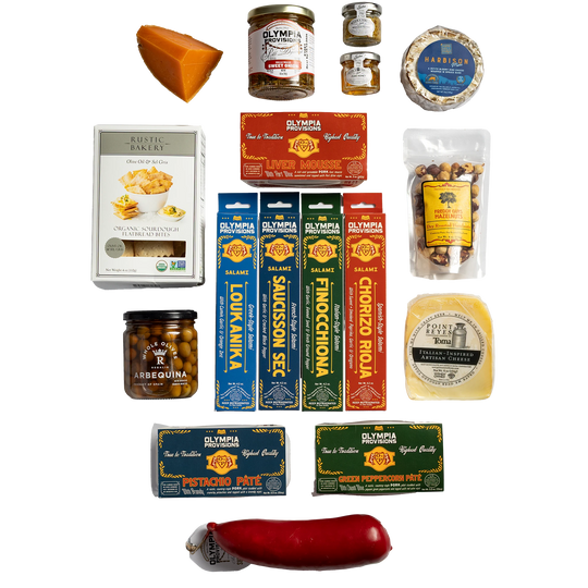 A curated assortment of gourmet food products including: four European-inspired Olympia Provisions salamis, two country-style pates, one red summer sausage, a jar of sweet onion pickles, a jar of olives, three cheeses, crackers, hazelnuts, and two small jars of preserves.