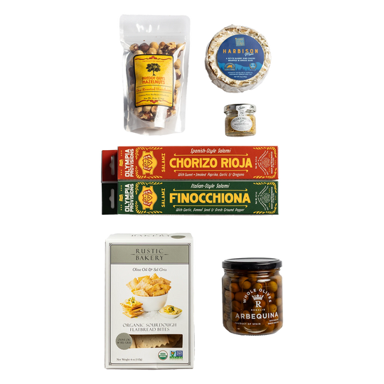 Two European-inspired Olympia Provisions salamis in boxes, Rustic Bakery crackers, Freddy guys hazelnuts, cheese, mustard, and olives.